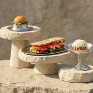 Stone stands with a sandwich and two small dishes on a stone surface